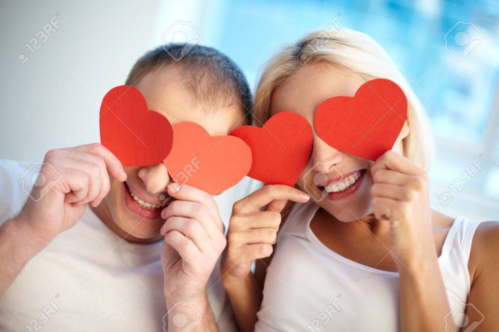 16633234 retrato de pareja feliz celebracion de los corazones rojos de papel por sus ojos