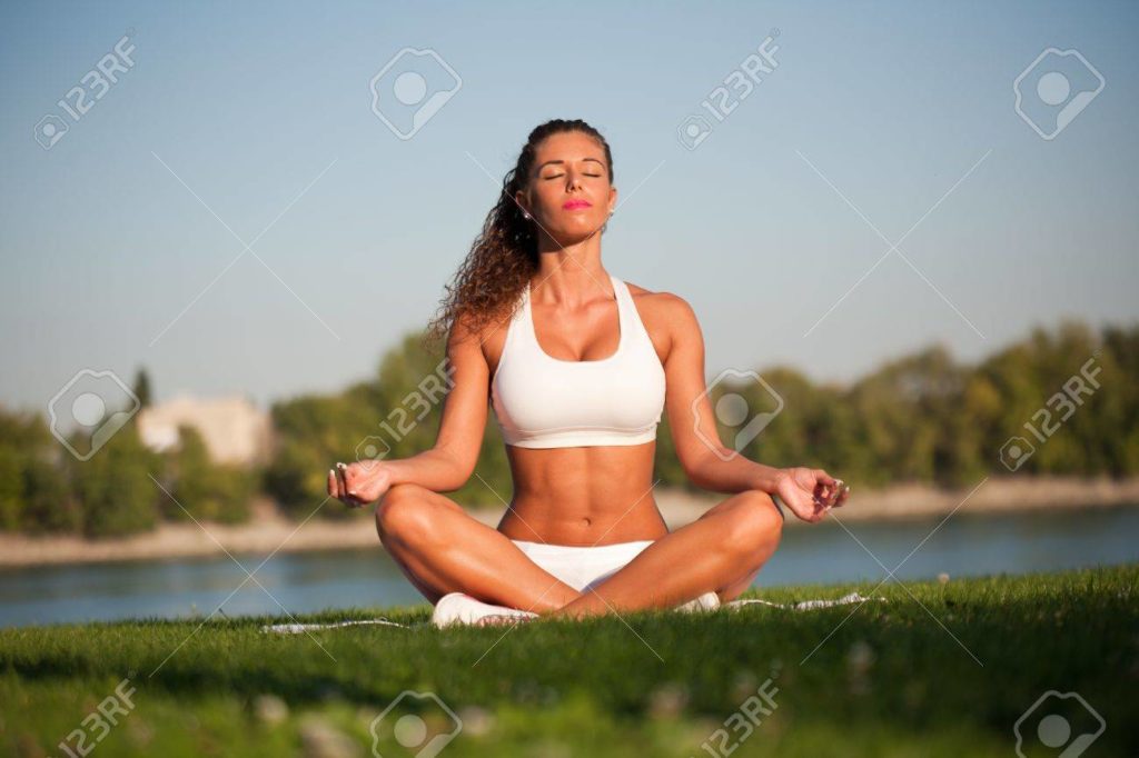 22062343 momento de tranquilidad muy en forma mujer joven en la relajacion de asiento yoga al aire libre