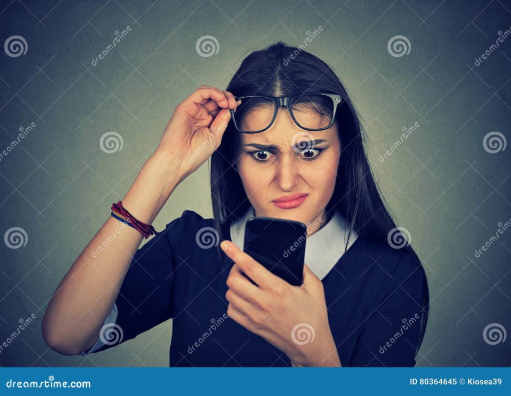 mujer confusa con los vidrios que tienen problema que ve el telefono celular 80364645