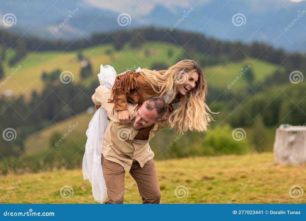 pareja corre risas novia salta sobre novios mostrando profundo amor por las montanas en segundo plano 277023441 1